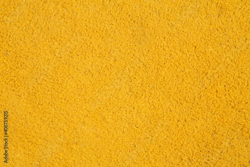 background - texture of bright yellow ground flooring in the playground, space for text, space for copy
