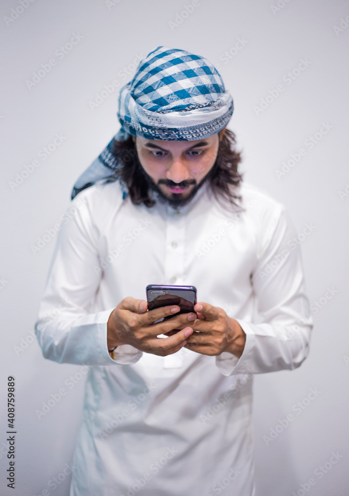 Religious man watching social media in the smart phone isolated on a grey background Religious man watching social media in the smart phone isolated on a grey background