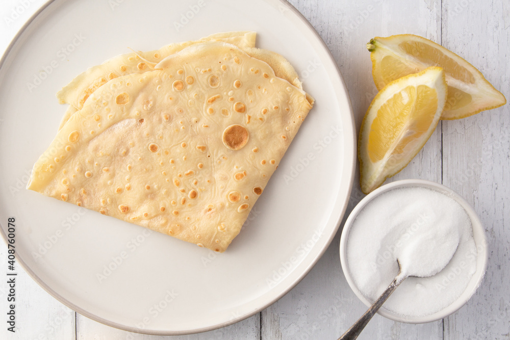 folded crepes on a plate with lemon and sugar folded crepes on a plate with lemon and sugar