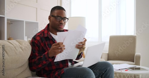 Man feeling relief on founding misplaced document while working on laptop