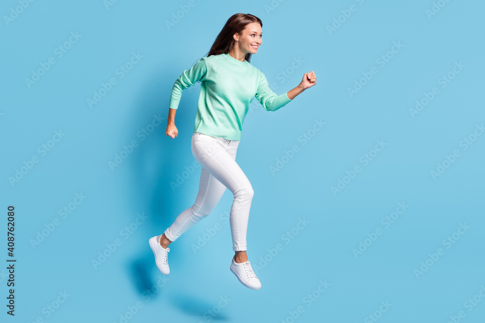 Profile photo of shiny cute girl wear casual outfit jumping running hands fists isolated blue color background