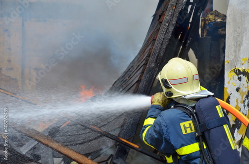 Firefighters spray water into the flames during a fire in an old industrial building 