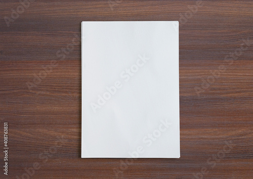 Stack of paper folios on wooden desk. high view
