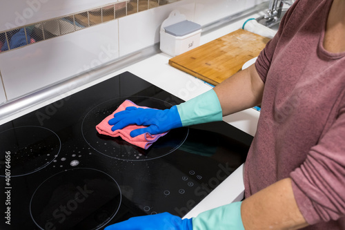 Cleaning the table in the house Sanitize the surface of the kitchen table with a disinfectant spray bottle, wash the surfaces with gloves. COVID-19 prevention indoor sanitizing.