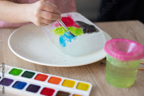 Child painting an ice  sensory activity  DIY.