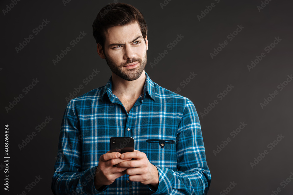 Brooding handsome guy looking aside and using cellphone Brooding handsome guy looking aside and using cellphone