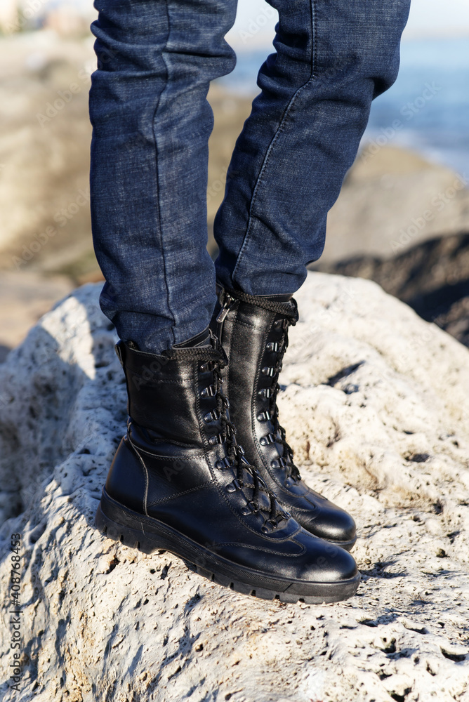 Unisex army black boots in military-style leather on laces for hiking in nature in the forest or mountains on a background