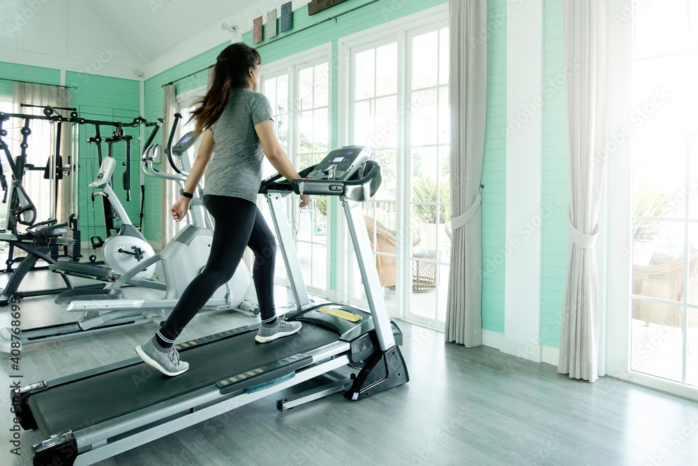 Woman walking exercise on a treadmill at home