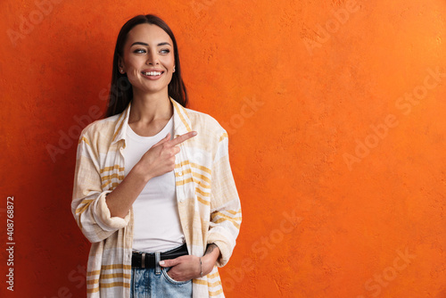 Happy woman pointing to the side over isolated