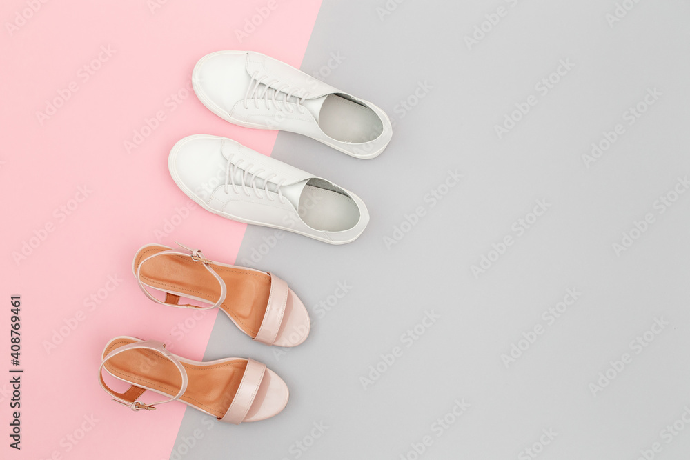 White sneakers and pink heeled sandals on grey and pink paper background. Stylish spring or summer woman's shoes in pastel colors. Trendy beauty female fashion background. Flat lay, top view. White sneakers and pink heeled sandals on grey and pink paper background. Stylish spring or summer woman's shoes in pastel colors. Trendy beauty female fashion background. Flat lay, top view.