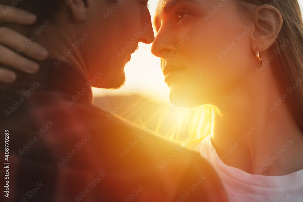 Close-up cropped portrait of a beautiful lovely couple enjoying each other on the sunset.