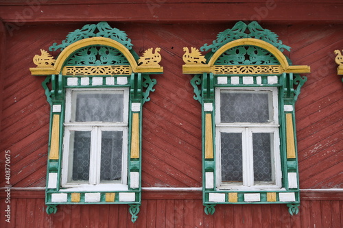 Ornamental windows with carved frames on vintage wooden rural house in Nerekhta town, Kostroma region, Russia. Building facade. Russian traditional national folk style in architecture. Russan landmark photo