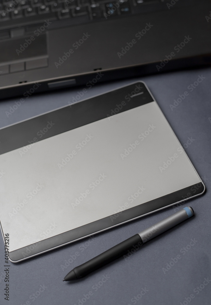 Graphic drawing tablet with pen on graphic designers desk, minimalist black and white background with blurred background Graphic drawing tablet with pen on graphic designers desk, minimalist black and white background with blurred background