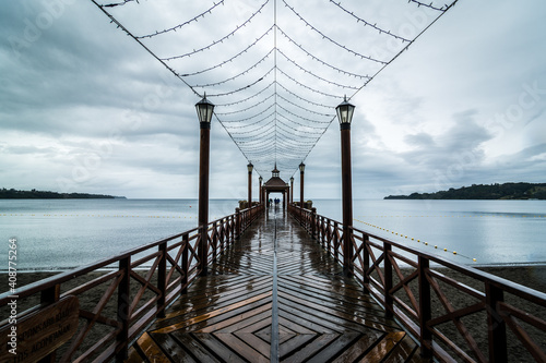 Wooden pier in Frutillar, Chile with the view of the Llanquihue lake under the cloudy sky photo
