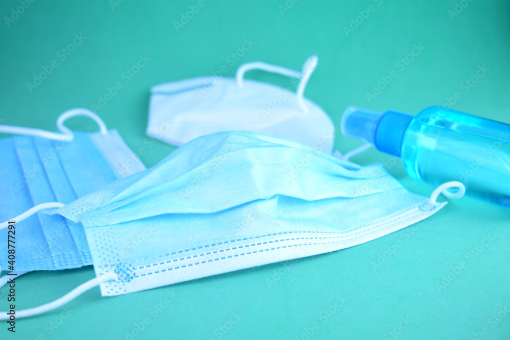 Hygienic and sanitary measures, coronavirus. Masks and hand sanitizer gel on blue background.