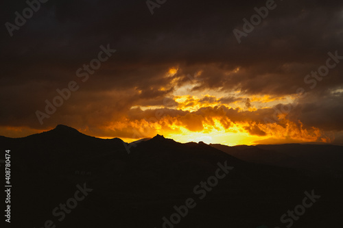 Fiery sunset in the mountains. Beautiful light from the sun.