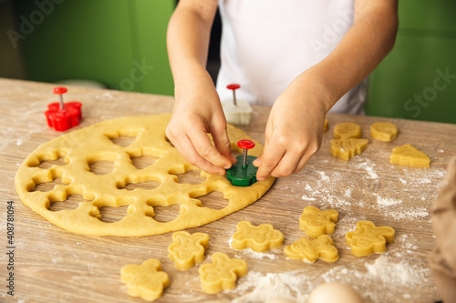 Indoor activity. Young child boy cooking in the kitchen. Making cookies. Closeup