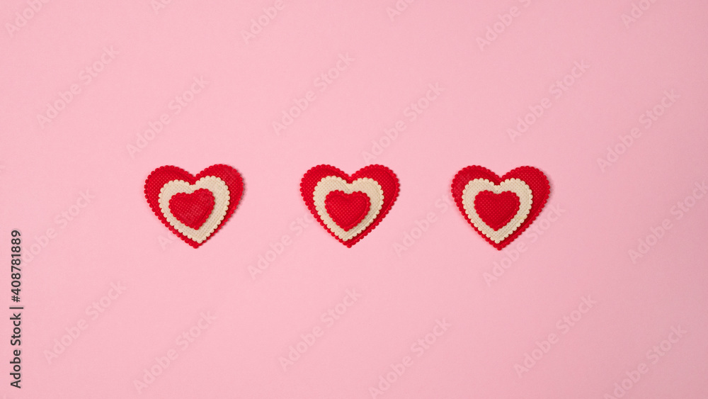 Red hearts on gently pink background. St Valentine’s day top view flat lay. Love romantic relationship concept. Copy space for text. The symbol of love and family.