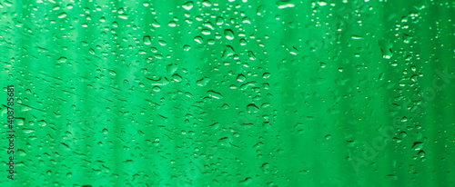 Water drops on the window pane. Tropical rain. Abstract green background, gradient. 