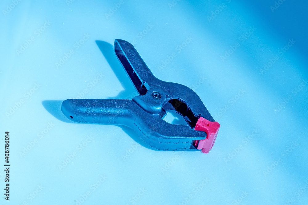Spring clip on a colored background close-up Spring clip on a colored background close-up