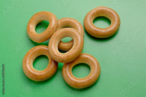 Baked dough rings on a green background close-up