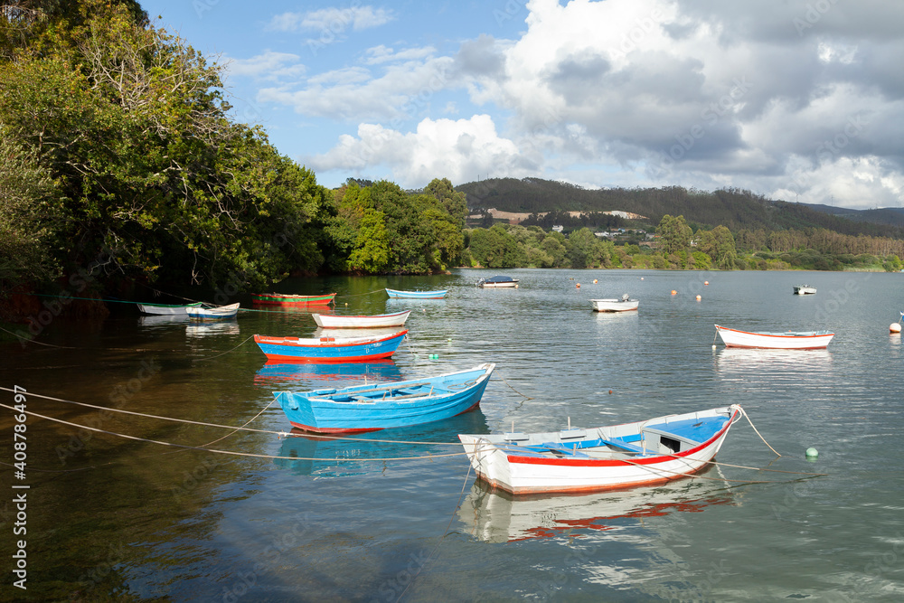 Fishing boats moored in a peaceful seascape near the village of Ladrido, in the Ortigueira estuary, in northern Galicia, Spain. Fishing boats moored in a peaceful seascape near the village of Ladrido, in the Ortigueira estuary, in northern Galicia, Spain.