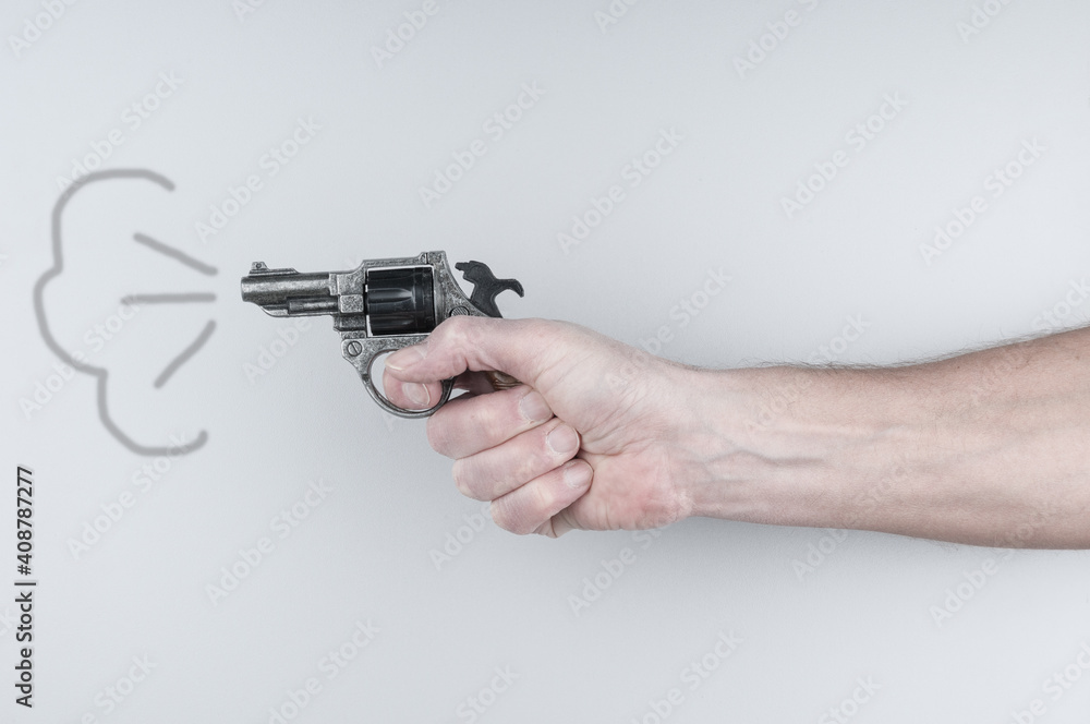 Man's hand holding revolver on gray background Man's hand holding revolver on gray background