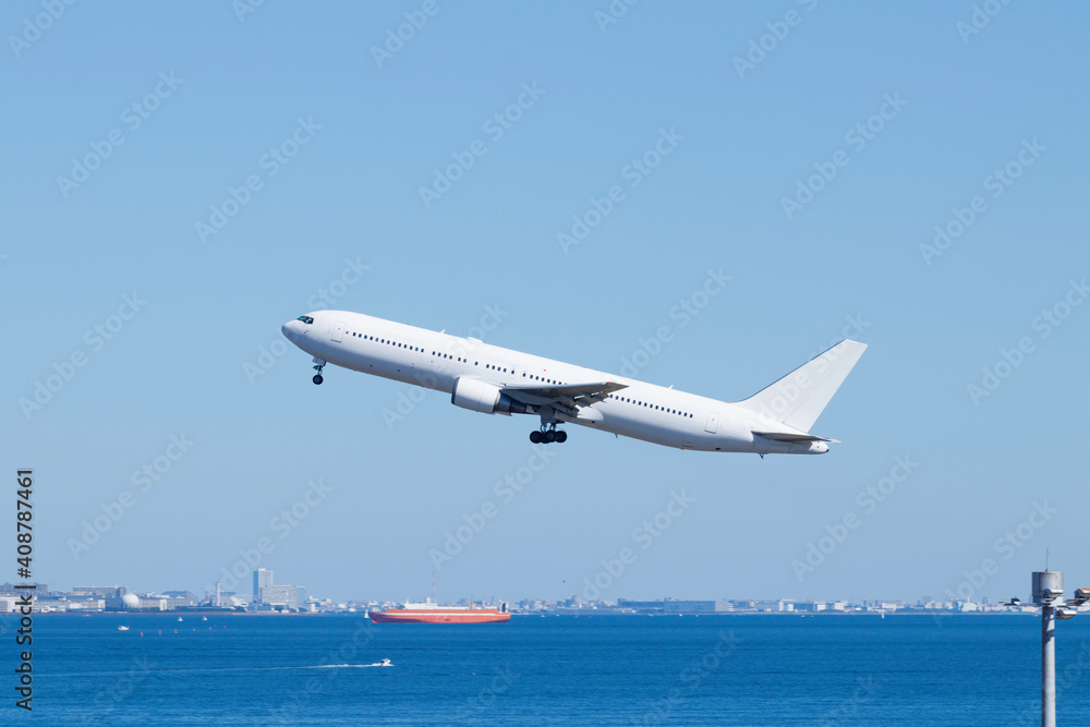 青空を背景に羽田空港を離陸する飛行機 青空を背景に羽田空港を離陸する飛行機