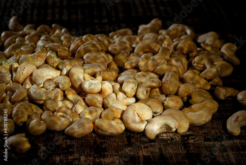 Cashew close up. Texture of nuts. Lots of nuts in a pile. Contrasting dramatic light as an artistic effect.