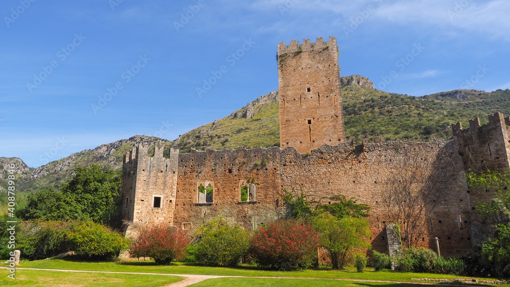Medieval ruins of castle Caetani family are surrounded by magnificent Ninfa garden with flowering plants of various colors. Monti Lepini valley near Norma and Sermoneta. Beautiful Italian landscape. Medieval ruins of castle Caetani family are surrounded by magnificent Ninfa garden with flowering plants of various colors. Monti Lepini valley near Norma and Sermoneta. Beautiful Italian landscape.