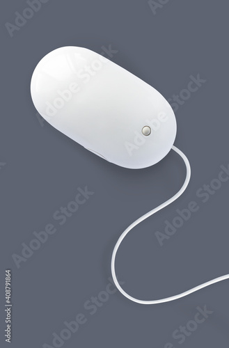 Simple white computer mouse with cord isolated on dark grey background, minimal style