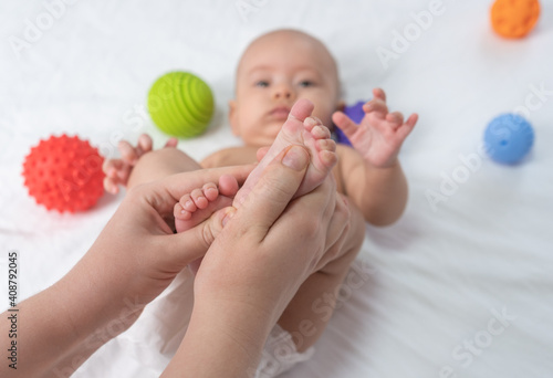 Doctor giving foot massage to baby. Selective focus