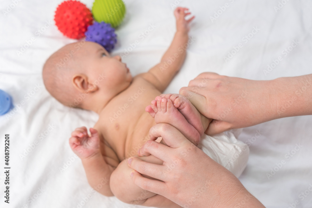Mom is doing gymnastics with the baby. Baby massage. Selective focus Mom is doing gymnastics with the baby. Baby massage. Selective focus