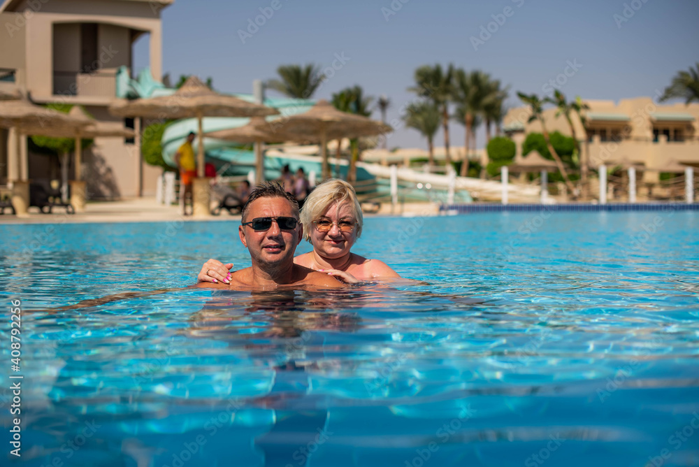Happy family, married couple or friends relaxing and have fun in swimming pool