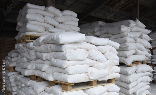 Bags of cement are stacked in the store's warehouse, ready for sale.