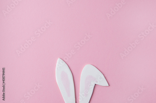 Creative layout, cute bunny ears on a pink background, Easter minimalist concept, flat lay, top view