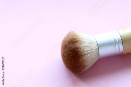 big fluffy make up brush on pink background