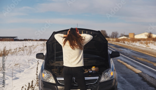 Caucasian female having a problem with car on a roadtrip Upset woman emotionally reacting on overheated car standing on the roadside with the open hood