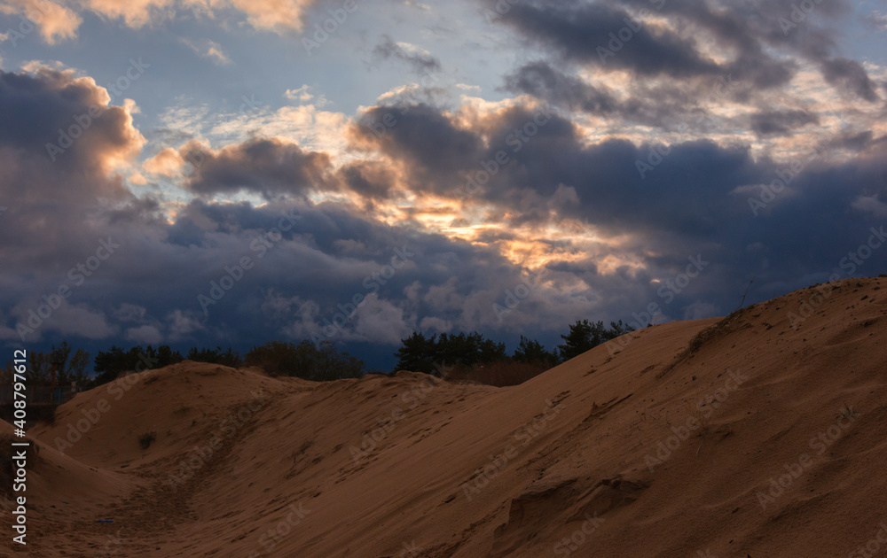 volumetric clouds on a background of sandy desert at sunset