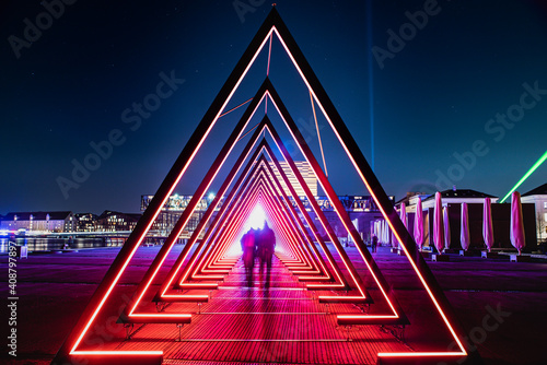 Obraz na płótnie Light tunnel or gate of light installation consists of many triangular gates lit by bright lights
