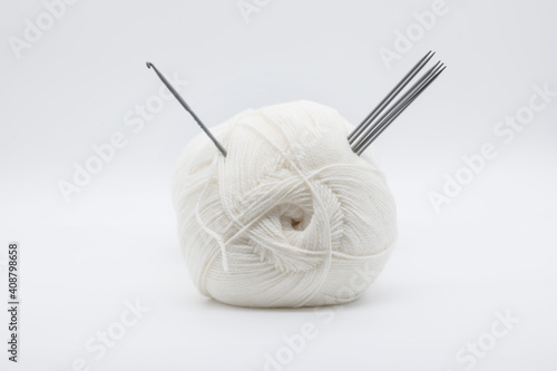 White yarn with needles and crochet