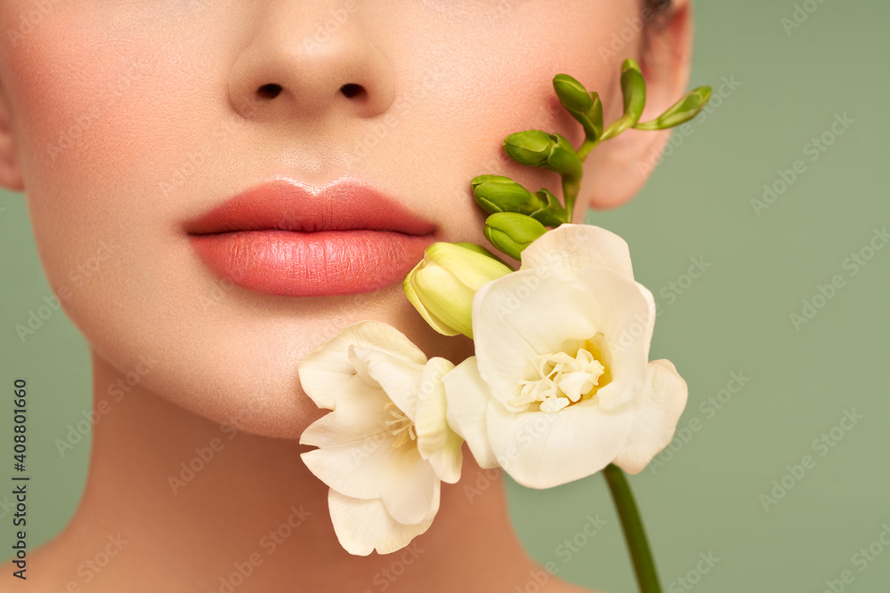 Beautiful model with a flower. Perfect woman face makeup close up. Lipstick. Beautiful model with a flower. Perfect woman face makeup close up. Lipstick.