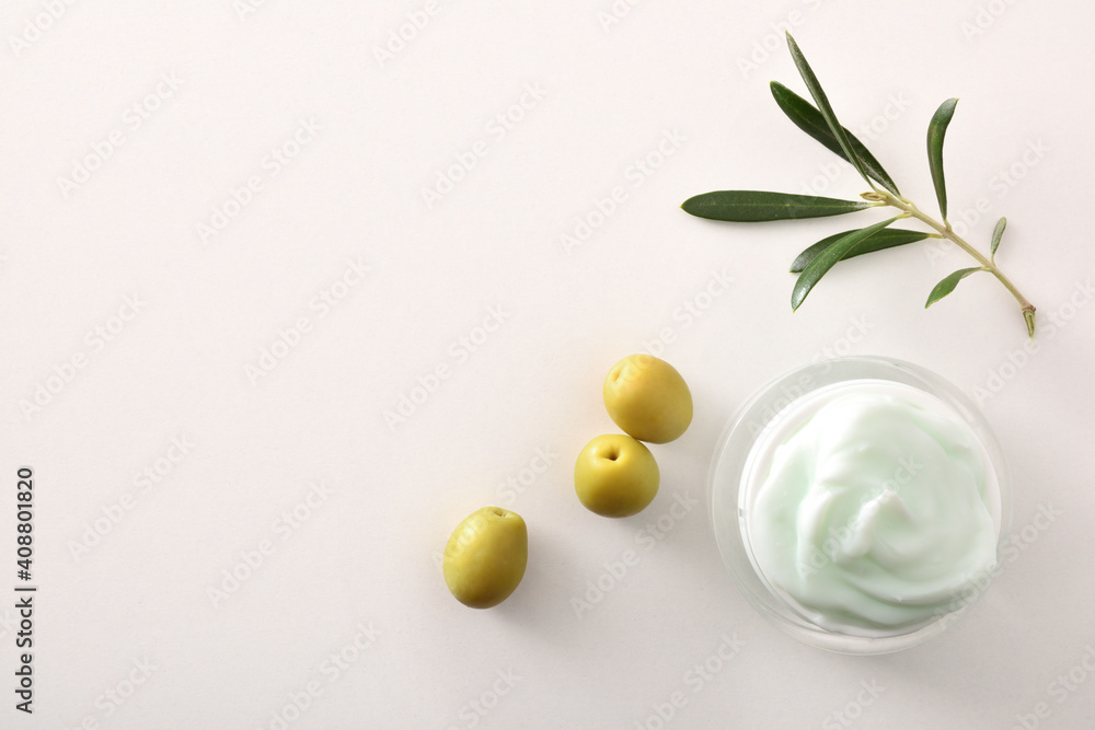 Olive moisturizing cream for skin on white table top detail Olive moisturizing cream for skin on white table top detail