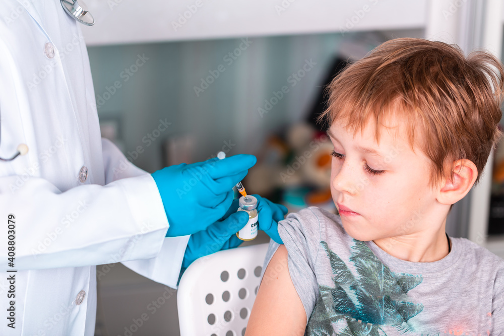 Fototapeta premium Doctor or nurse in uniform and gloves wearing face mask protective in lab making an injecion holding vaccine bottle with COVID-19 Coronovirus vaccine label