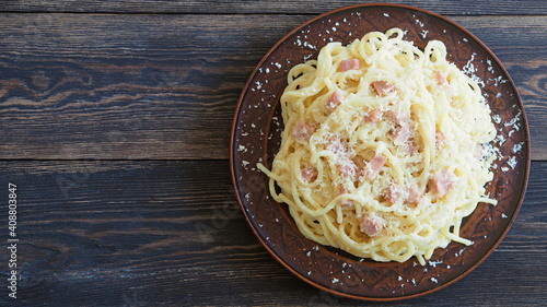 Carbonara pasta on a wooden table with a place to describe