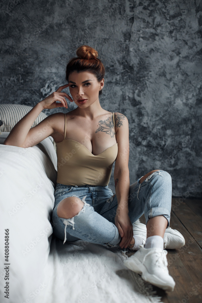 pretty woman near bed indoors in interior. serious model posing pretty woman near bed indoors in interior. serious model posing