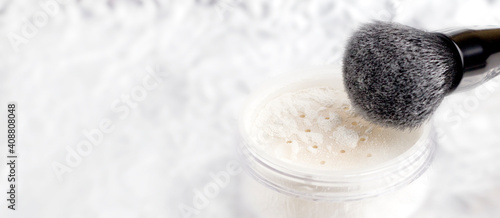 White matting powder with a black brush on a white background.