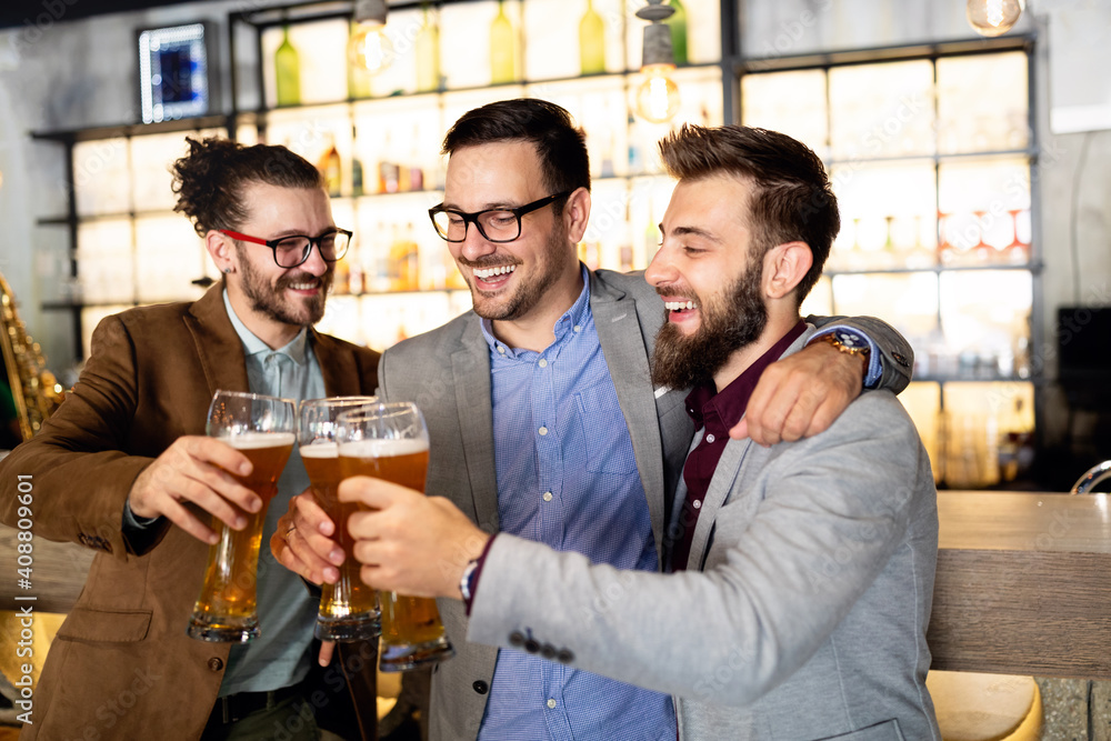 Fototapeta premium Young businessmen are drinking beer, talking and smiling while resting at the pub