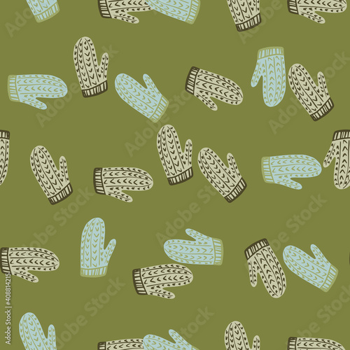 Knitted wool mittens seamless pattern in doodle style. Cozy christmas clothes with green background.