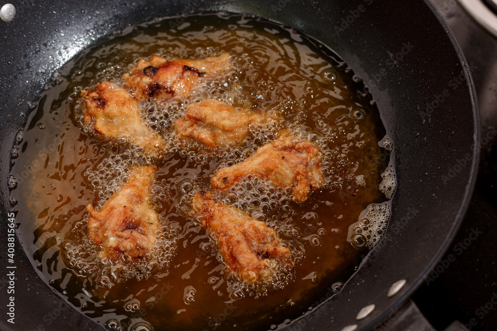 Close up fried chicken wings in boiling oil Close up fried chicken wings in boiling oil